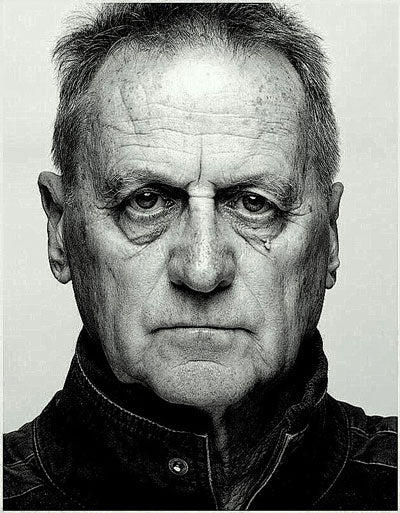 Portraitfoto des Künstlers in schwarz weiß, schaut direkt in die Kamera