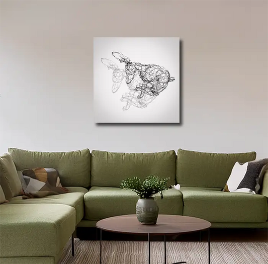 Fineart Print der Drahtfigur eines rennenden Hasen mit Schatten vor hellem Hintergrund, an heller Wand mit grünem sofa