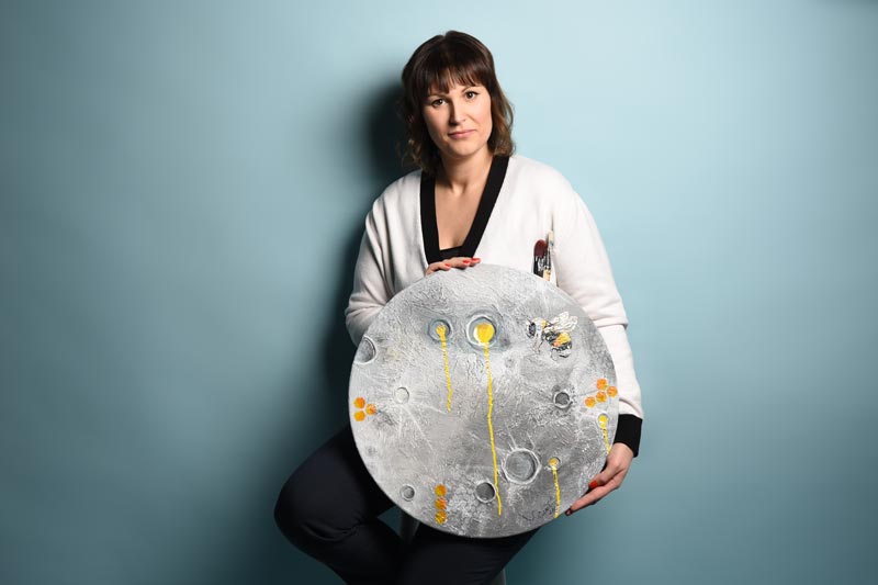 Portrait Sarah Schuber, hält ein rudes Bild in den Händen