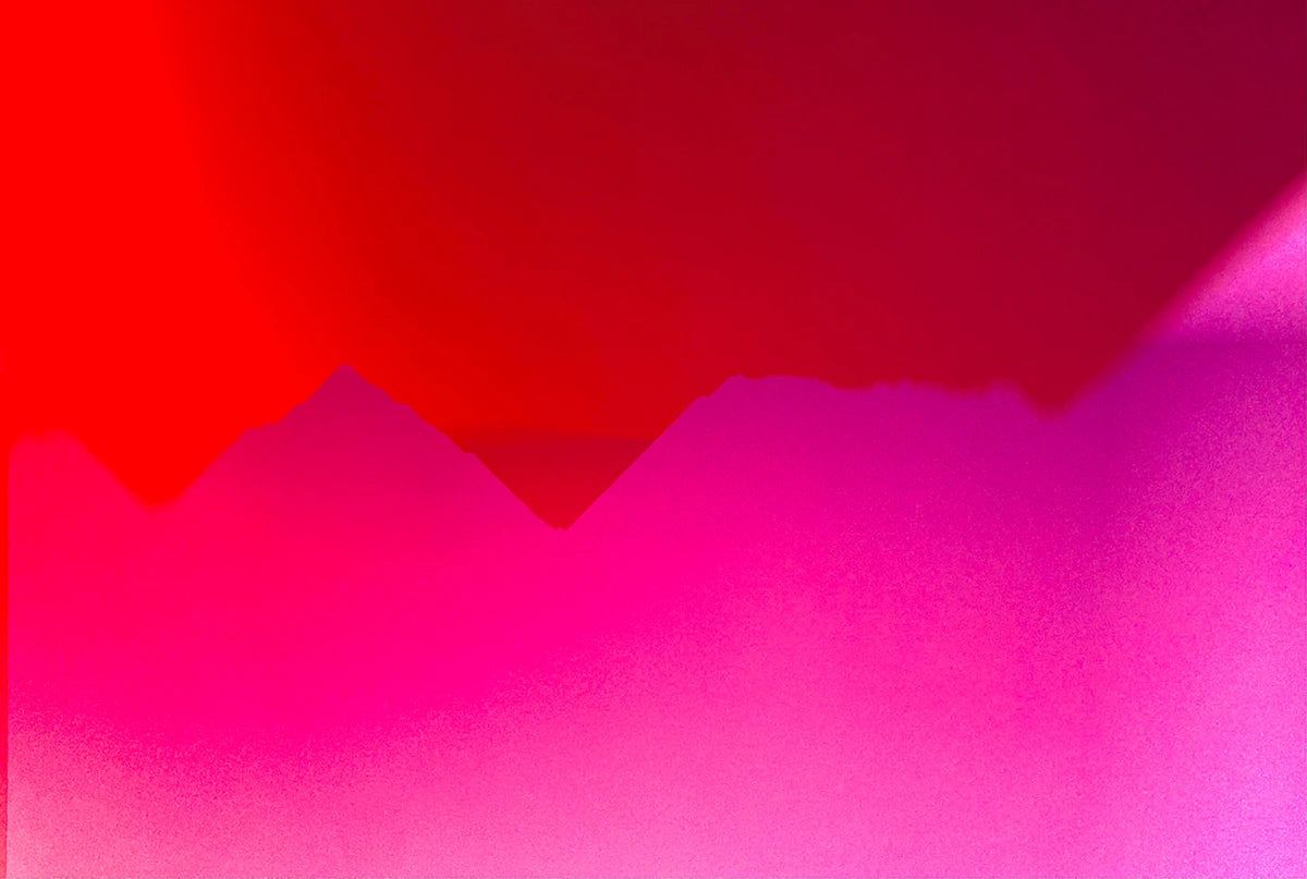 Das abstrakte Foto zeigt abstrakte Strukturen in pink und rot die an Berge erinnern.