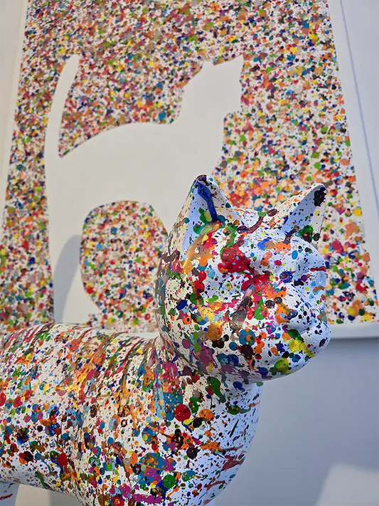 Eine bunte Katze steht vor einer bunten Leinwand mit den Umrissen der Katze, Details der Katze.