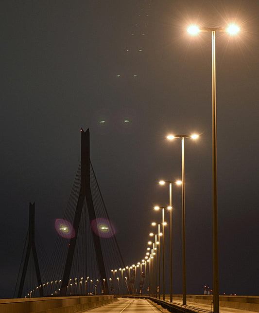 Foto der Köhlbrandbrücke in Hamburg bei Nacht, Lampen beleuchten die Straße