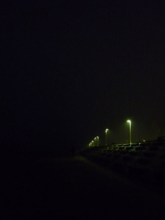 EIn Foto der Insel Norderney bei Nacht, nur einzelne Lampen sind zu erkennen.