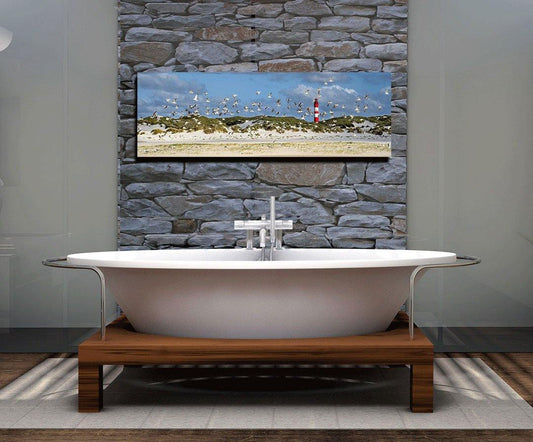 Möven fliegen über einen Strand mit Leuchtturm, Bild an einer Wand über Badewanne
