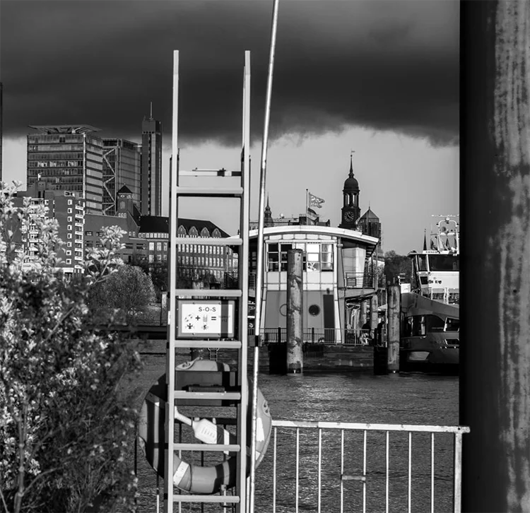 schwarz weiß Foto einer alternative Ansicht von Hamburg mit Michel aus ungewöhnlicher Perspektive an den Landungsbrücken