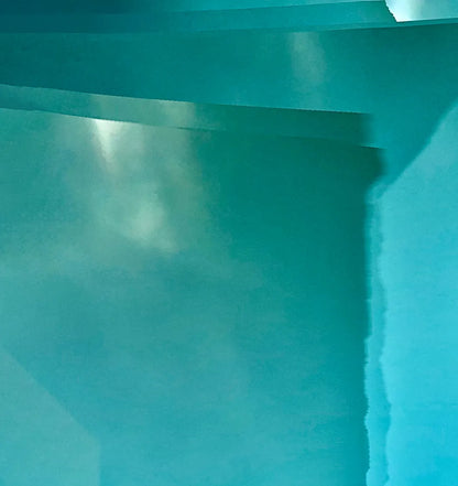Abstraktes Foto das blaue und türkise Strukturen zeigt die durch Stoff fotografiert wurden, Detailansicht die an grünliche Gletscherstrukturen erinnern. 