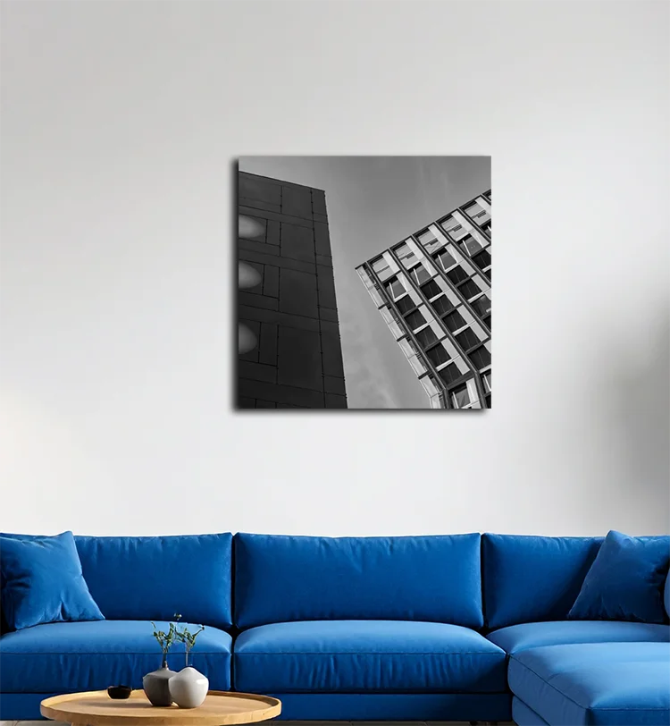 Die tanzenden Türme in Hamburg, nach links geneigt, rechts ein dunkles Gebäude, an heller Wand hängend mit blauem Sofa