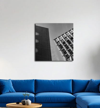 Die tanzenden Türme in Hamburg, nach links geneigt, rechts ein dunkles Gebäude, an heller Wand hängend mit blauem Sofa