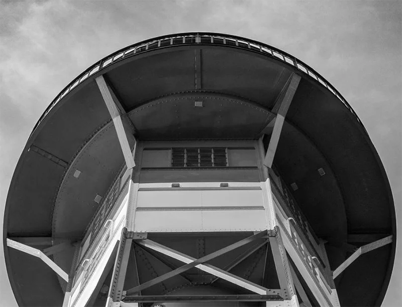 Schwarz-weiß foto eines  Leutchtturms an der Elbe, von unten gesehen, symetrischer Aufbau, Detailansicht der oberen Plattform
