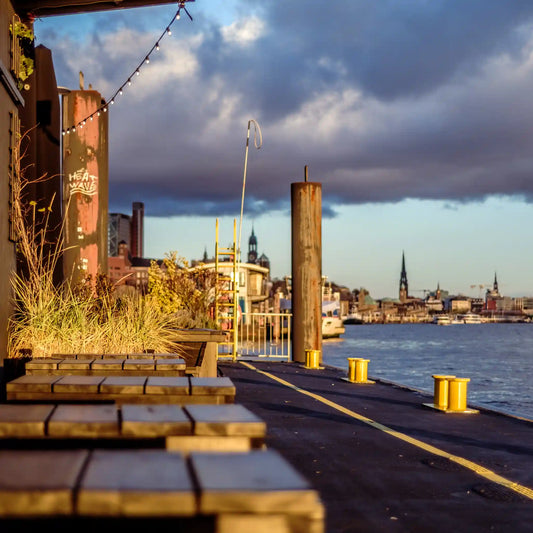 Farbfoto vom Anleger hinter der Fischauktionshalle mit Kirchen und gelben Pollern