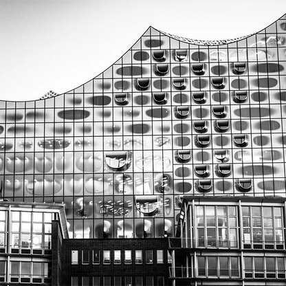 Schwarz-weiß Foto der Elbphilharmonie, mit anderem Gebäude im Vordergrund