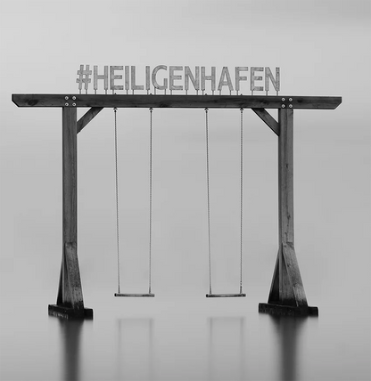 Der Schriftzug Heiligenhafen auf einer Schaukel im Wasser, s/w Langzeitbelichtung, detail  schaukel