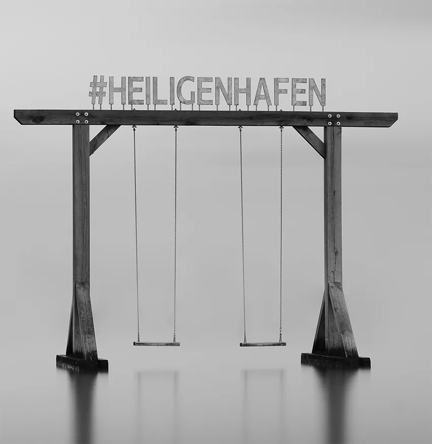 Der Schriftzug Heiligenhafen auf einer Schaukel im Wasser, s/w Langzeitbelichtung, detail  schaukel, 120 x 90 cm, Thomas Dalecki, Kunst-Direkt.de