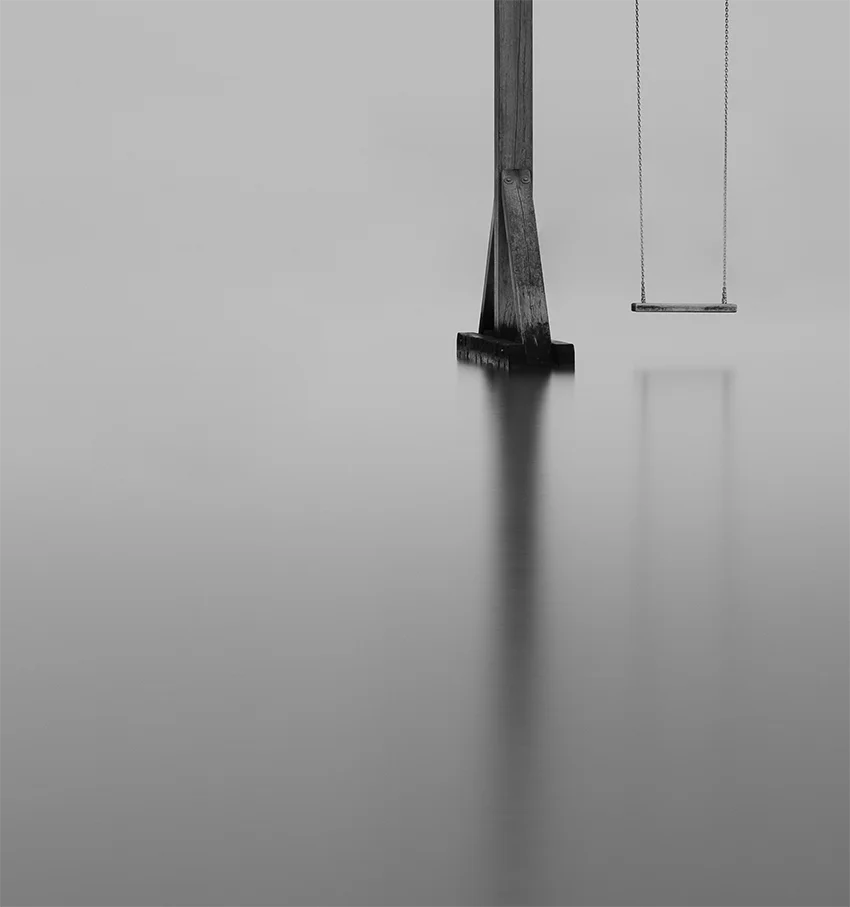 Der Schriftzug Heiligenhafen auf einer Schaukel im Wasser, s/w Langzeitbelichtung, detail wasser mit Pfahl, 120 x 90 cm, Thomas Dalecki, Kunst-Direkt.de