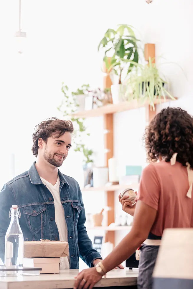 Foto eine Künstlers der ein Bild an an eine Kundin verkauft