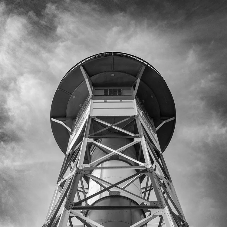 Schwarz-weiß foto eines  Leutchtturms an der Elbe, von unten gesehen, symetrischer Aufbau