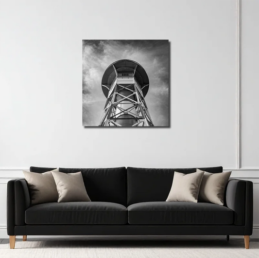 Schwarz-weiß foto eines  Leutchtturms an der Elbe, von unten gesehen, symetrischer Aufbau, an heller Wand hängend mit schwarzem Sofa