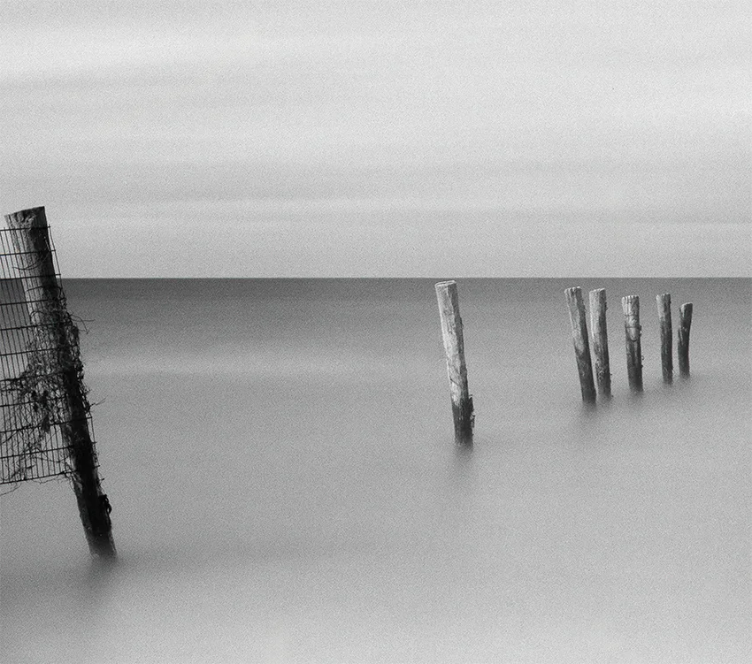 Pfähle stehen im Meer, Nebel, Langzeitbelichtung, horizong weit, s/w foto, querformat, detail pfähle horizont