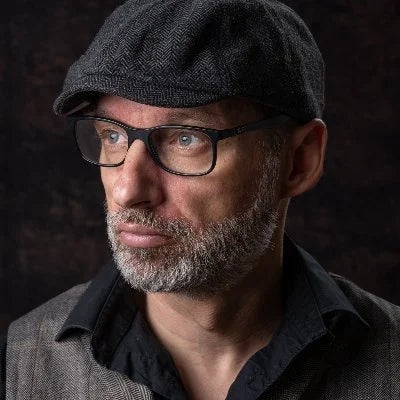 Portraitfoto des Künstlers Thomas Dalecki, mit Hut und Brille, zur Seite schauend Kunst-Direkt.de