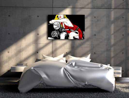 Eine Frau mit rotem Kleid und blonden Haaren sitzt auf einem Motorrad, an grauer Betonwand hängend in einem Schlafzimmer